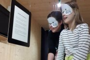 Kinder tragen eine Augenbinde und ertasten in der Ausstellung.