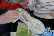 Ein Schüler putzt die Sohle eines Sneakers mit einem Schmutzradierer