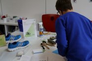Verschiedene Utensilien zur Schuhpflege liegen auf einem Tisch aus