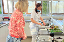 Zwei Frauen stehen in Küche vor Arbeitsplatte, auf der mehrere Schüsseln stehen