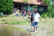 Am Ufer beobachten Kinder die Wasseroberfläche und den Boden. 