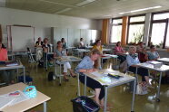 Teilnehmer sitzen im Klassenzimmer.